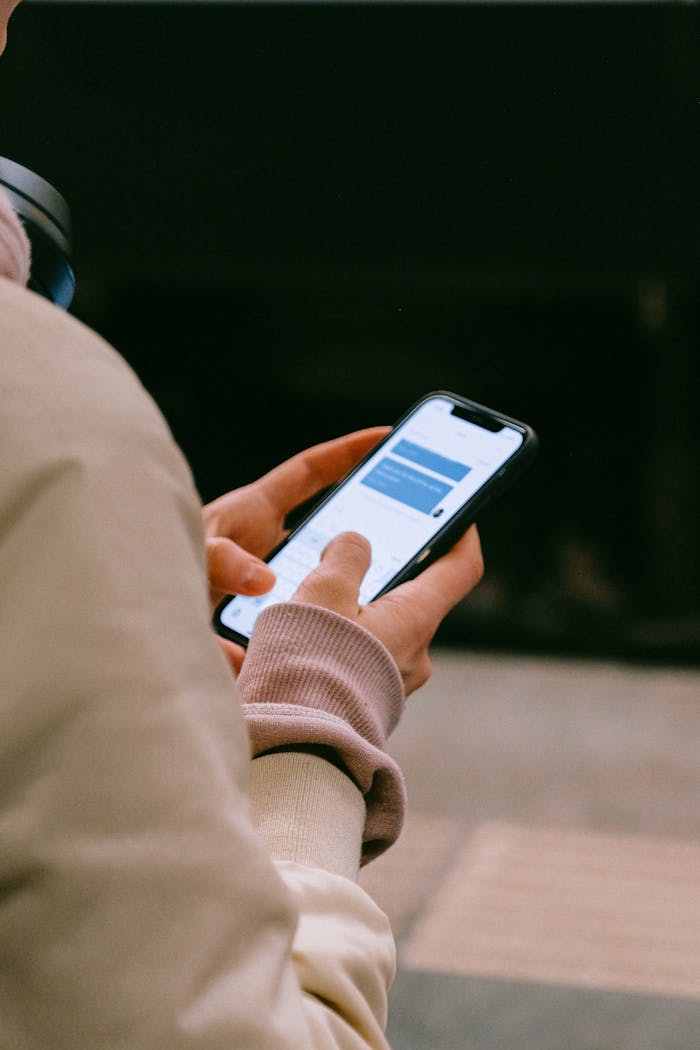 A person using a smartphone for texting, focusing on their hands and device screen.